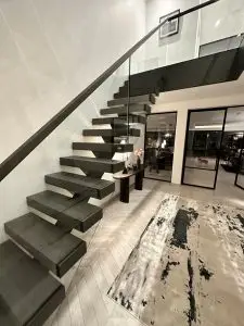 Central spine stair in open-plan space with frameless glass