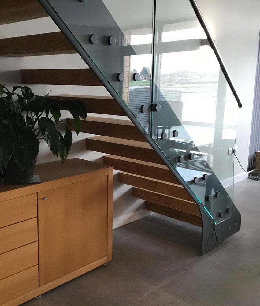 Elegant glass staircase with wooden steps and metal supports.